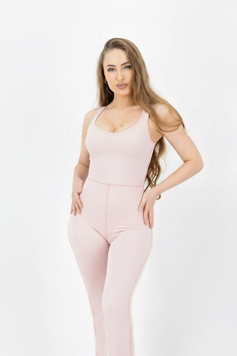 Woman wearing a light pink bodysuit against a white background
